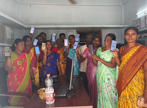 Farmers at the Bellamkonda Horticulture Farmers Producer Company Ltd office show off the FarmerChat application on their phones, that they use diligently